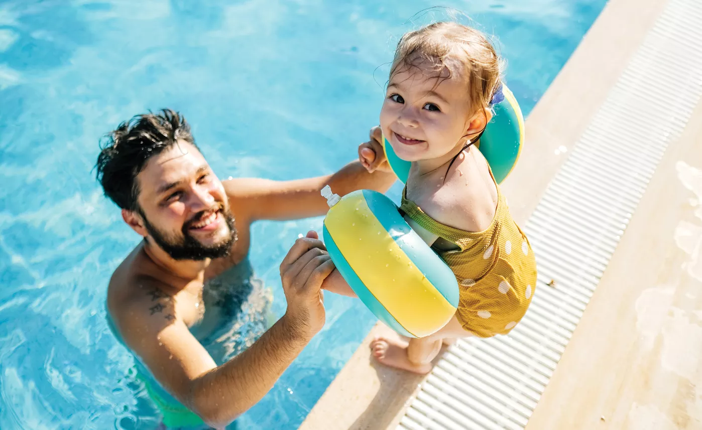  Un person et son enfant à la piscine.
