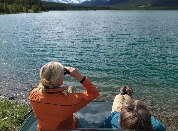  Two people sitting lakeside
