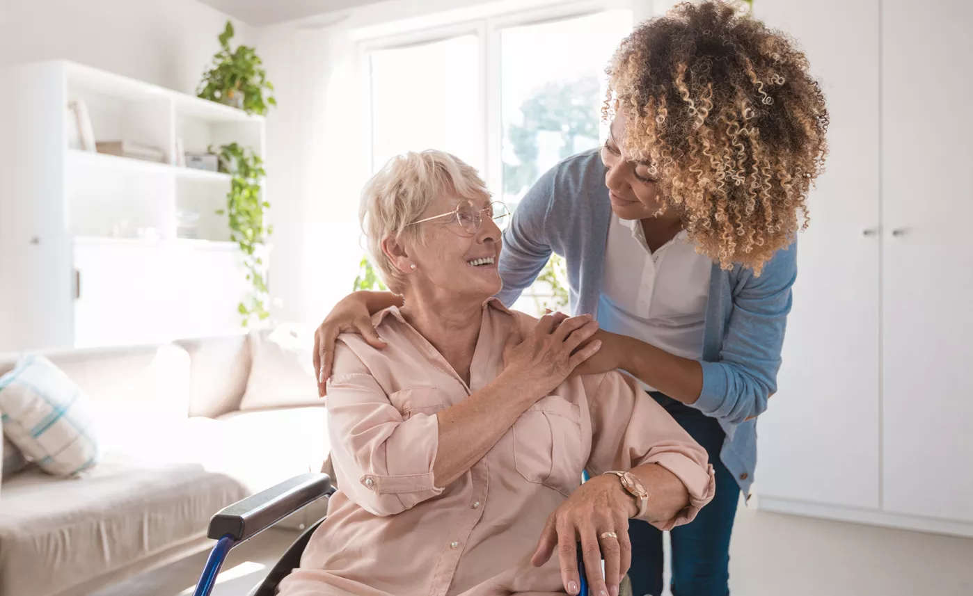  An elderly women and her long-term caregiver share a hug.
