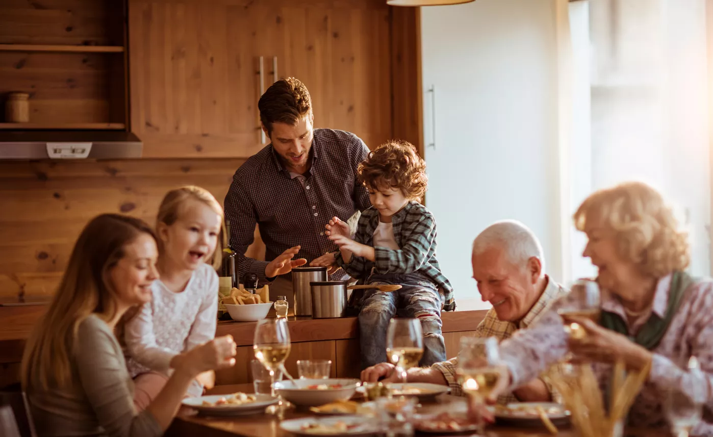  Trois générations d’une même famille cassent la croûte dans la cuisine.
