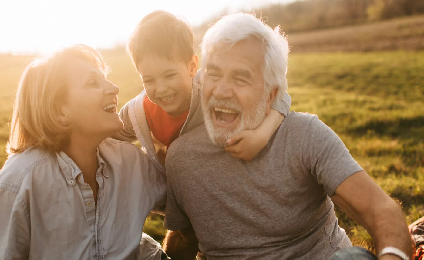  Un petit-fils et ses grands-parents s’embrassent en riant ensemble.
