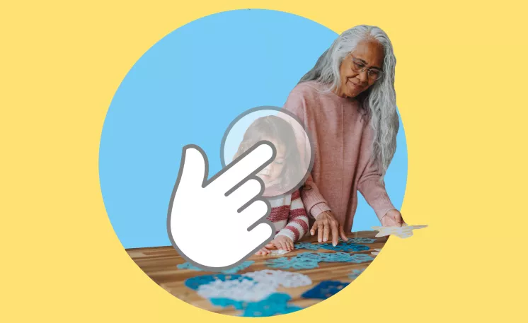 An elderly adult making crafts on a table with their grandchild.