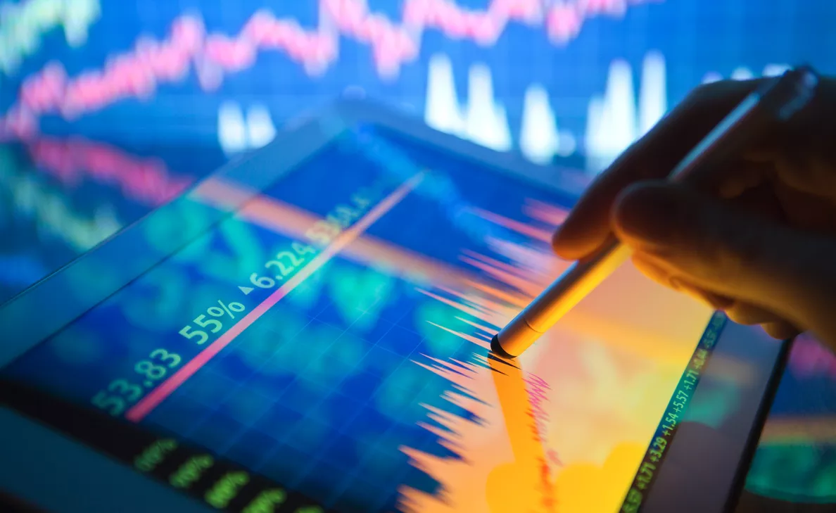 Gros plan d'un stylet et d'une tablette représentant des graphiques financiers
