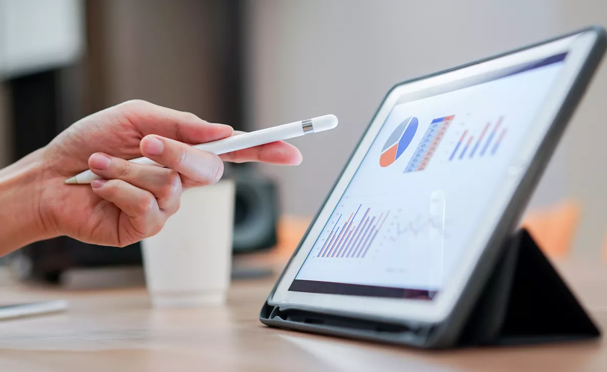 Une tablette sur laquelle des tableaux et des graphiques financiers sont affichés.