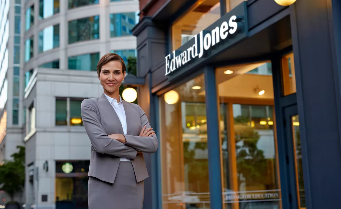 An Edward Jones associate stands outside of an Edward Jones branch.