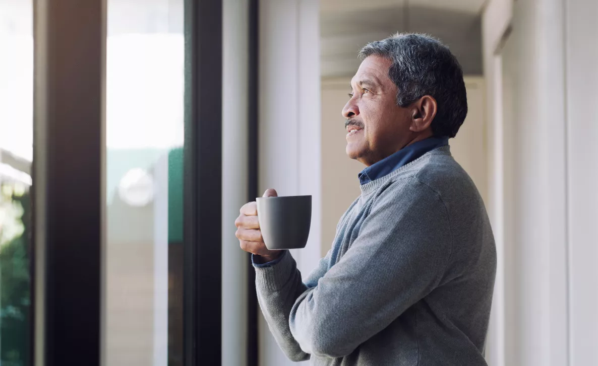  Man looking out window, drinking coffee
