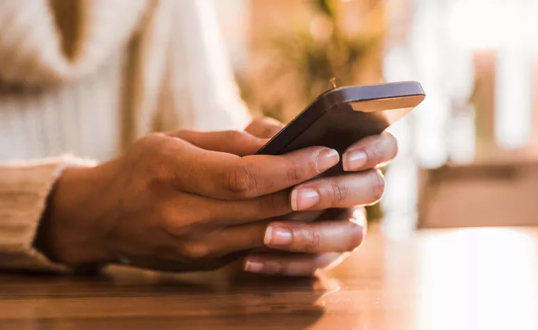 An Edward Jones client reads a text message on her mobile phone. An Edward Jones client reads a text message on her mobile phone.