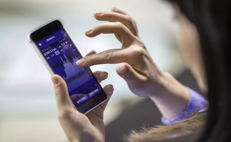 Une femme cherche des nouvelles sur les marchés boursiers sur son téléphone intelligent. Une femme cherche des nouvelles sur les marchés boursiers sur son téléphone intelligent.