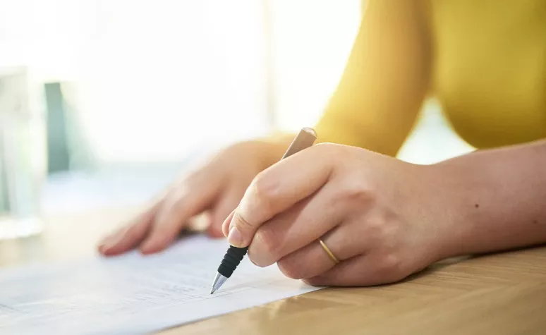 Une femme coche les tâches d’une liste sur une feuille de papier. Une femme coche les tâches d’une liste sur une feuille de papier.