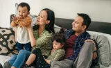 Family sitting in a couch and playing with children
