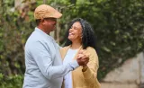 Two mature people embracing and smiling.