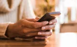 Une cliente d’Edward Jones lit un message texte sur son téléphone cellulaire.
