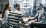 Un couple de jeunes rencontre un conseiller financier pour discuter des styles de placement.