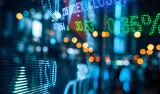 Blurred electronic stock ticker display with market numbers and lights.