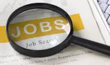 Magnifying glass highlighting the word “JOBS” on a job search page.