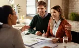  financial advisor meets with a young couple.