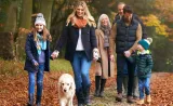 Une famille se promenant avec son chien.