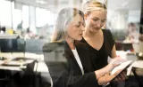 Two Edward Jones analysts interpret information from a report and discuss strategies for their clients.