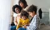 Une famille est assise pendant qu’un enfant joue sur une tablette.
